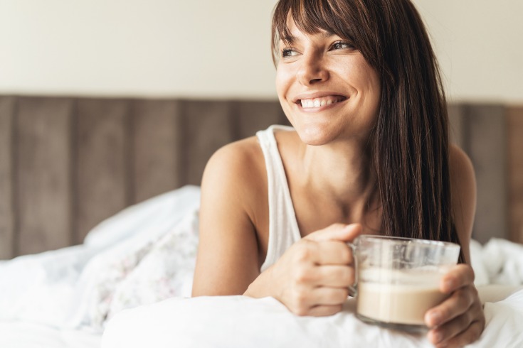 Mature woman sipping warm cup of coffee after a good night's sleep