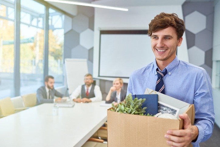 Office culture underpins how employees feel at work, this male office worker is smiling and very happy as he starts his career