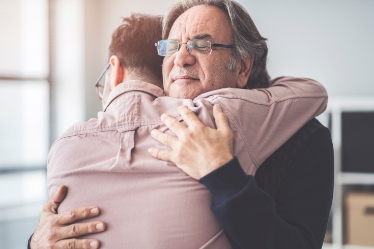 Son hugging his father who has gone through a traumatic event