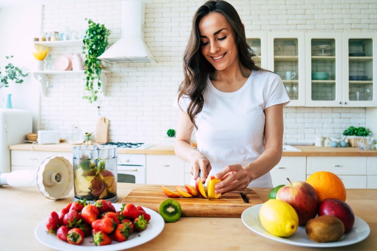 Young woman preparing a healthy meal to help improve wellbeing. 