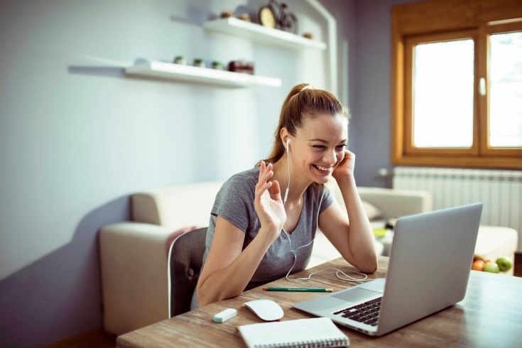 Young female working from home on a zoom call.