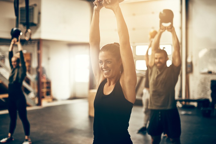 Young woman smiling and exercising at the gym