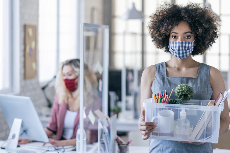 A young worker leaving an office after a redundancy due to the business downsizing.