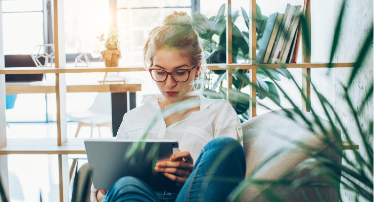 A woman working in an office with excellent physical office environment, comfortable furniture, natural light and plants