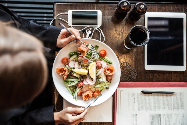 Female office worker eating a healthy, quick and easy salad. 