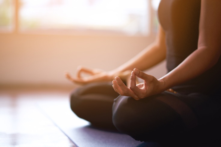  Women meditating as part of a workplace health and wellbeing program.