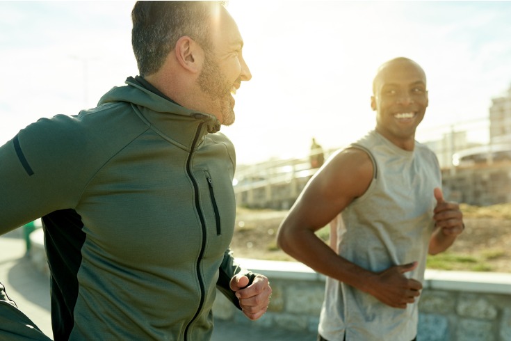 Two men running outside together and achieving work-life balance.