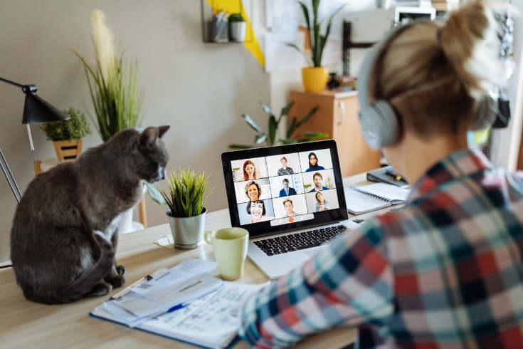 Woman speaking to her colleagues on a Zoom call while working from home during Mental Health Week.